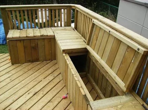 Wooden deck with built-in bench seating, storage compartments, and vertical railings