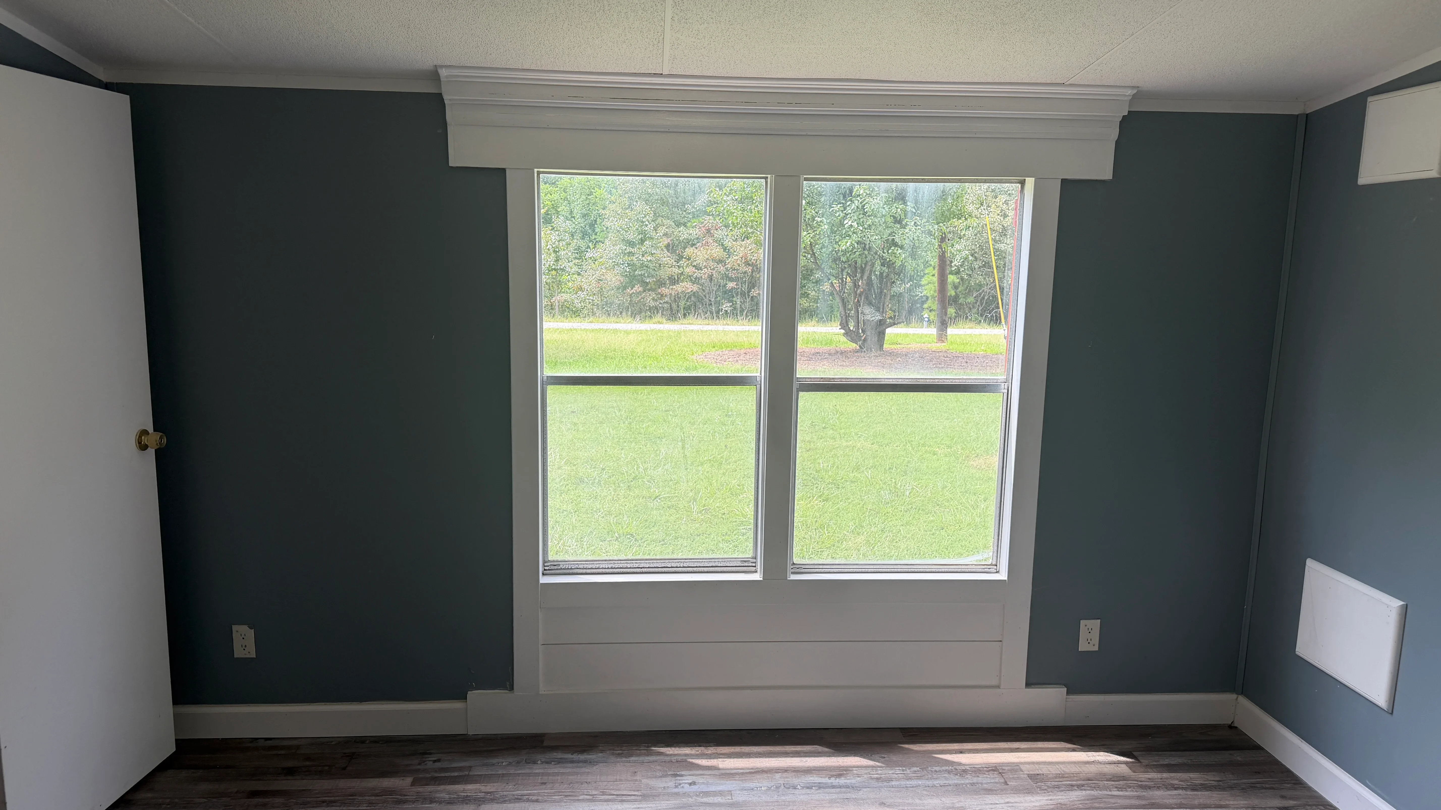 Interior room with two-tone painted walls, white crown molding, and double-hung windows with trim
